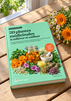 Ebook « 20 plantes médicinales » imprimé, posé sur une table de jardin près de fleurs de souci et de camomille